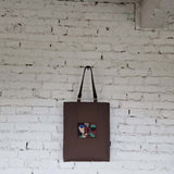 Full view of RIMALINUM handmade dark brown tote bag with abstract embroidery and green interior lining