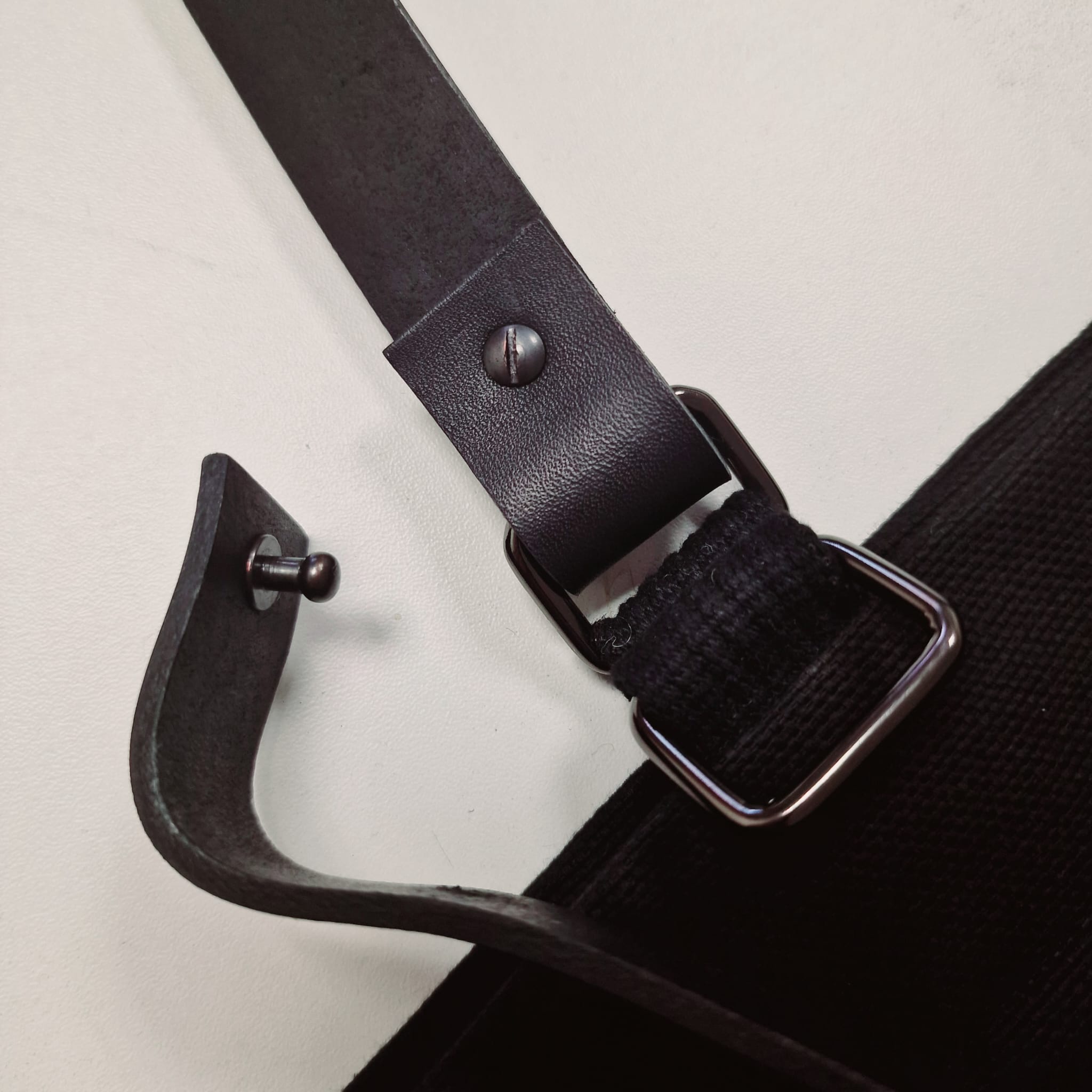 Close-up of detachable faux leather strap with screw button and metal ring attachment
