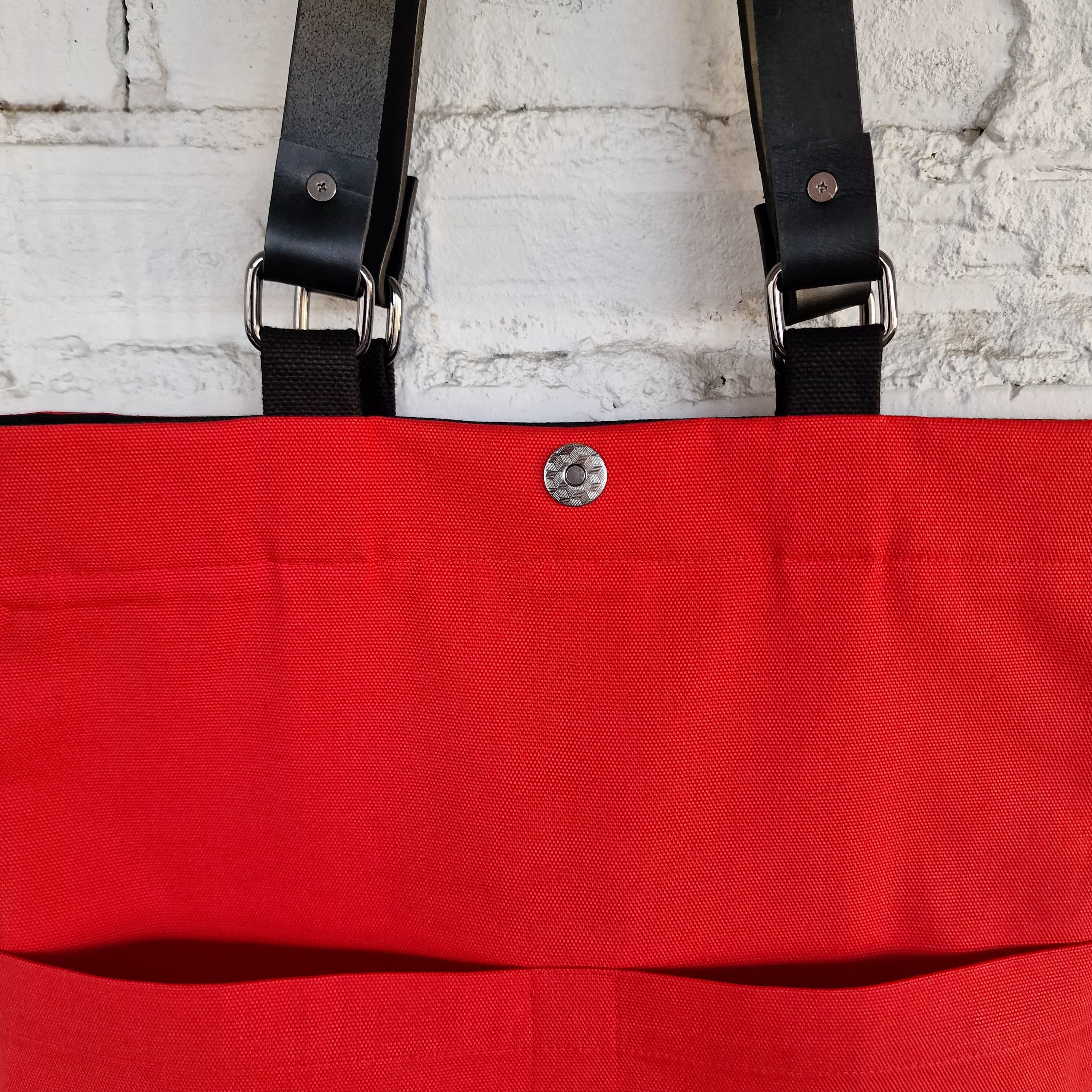 Interior view showing bright red lining, magnetic snap closure, and inner pocket detail
