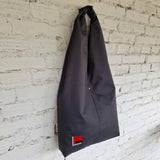 Front view of black HOBO bag with minimalist embroidered design