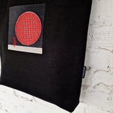 Bottom of the tote bag with visible red lining, metal D-ring, and contrast between outer fabric and lining