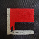 Detailed shot of embroidery design “The Path Finder” on the black shoulder bag