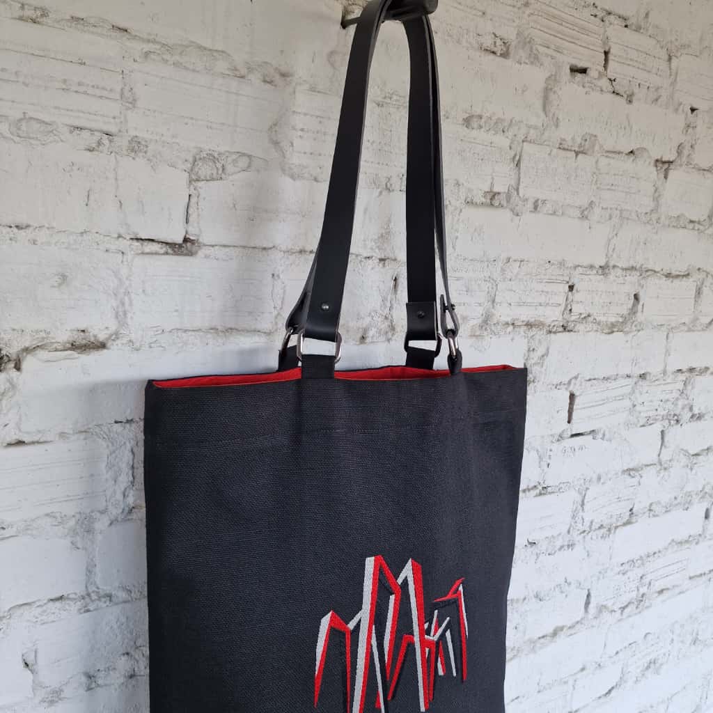 Interior view of handmade black tote bag with red fabric lining, crafted in Lithuania.