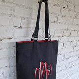 Interior view of handmade black tote bag with red fabric lining, crafted in Lithuania.