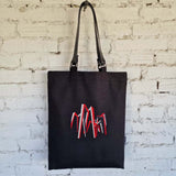 Full view of handmade black linen-cotton tote bag with leather straps and embroidered art motif