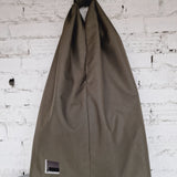 Khaki HOB bag on a gray surface with a white brick wall background 