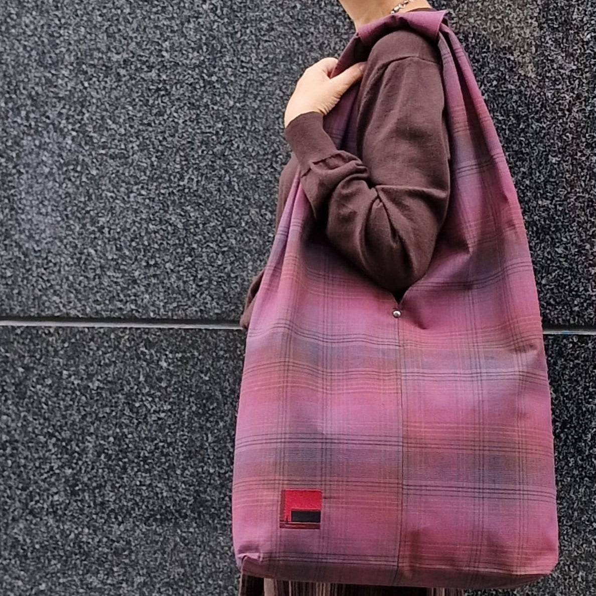 Woman carrying large burgundy plaid cotton hobo bag on shoulder – handmade casual tote for everyday