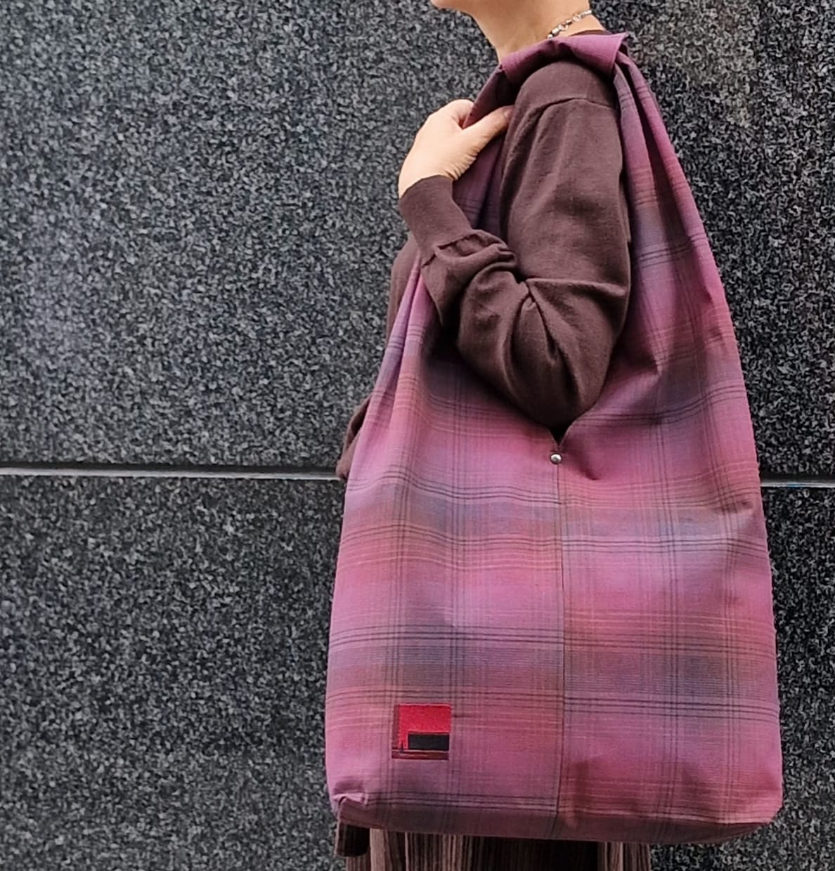 Woman carrying large burgundy plaid cotton hobo bag on shoulder – handmade casual tote for everyday