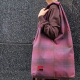 Woman carrying large burgundy plaid cotton hobo bag on shoulder – handmade casual tote for everyday