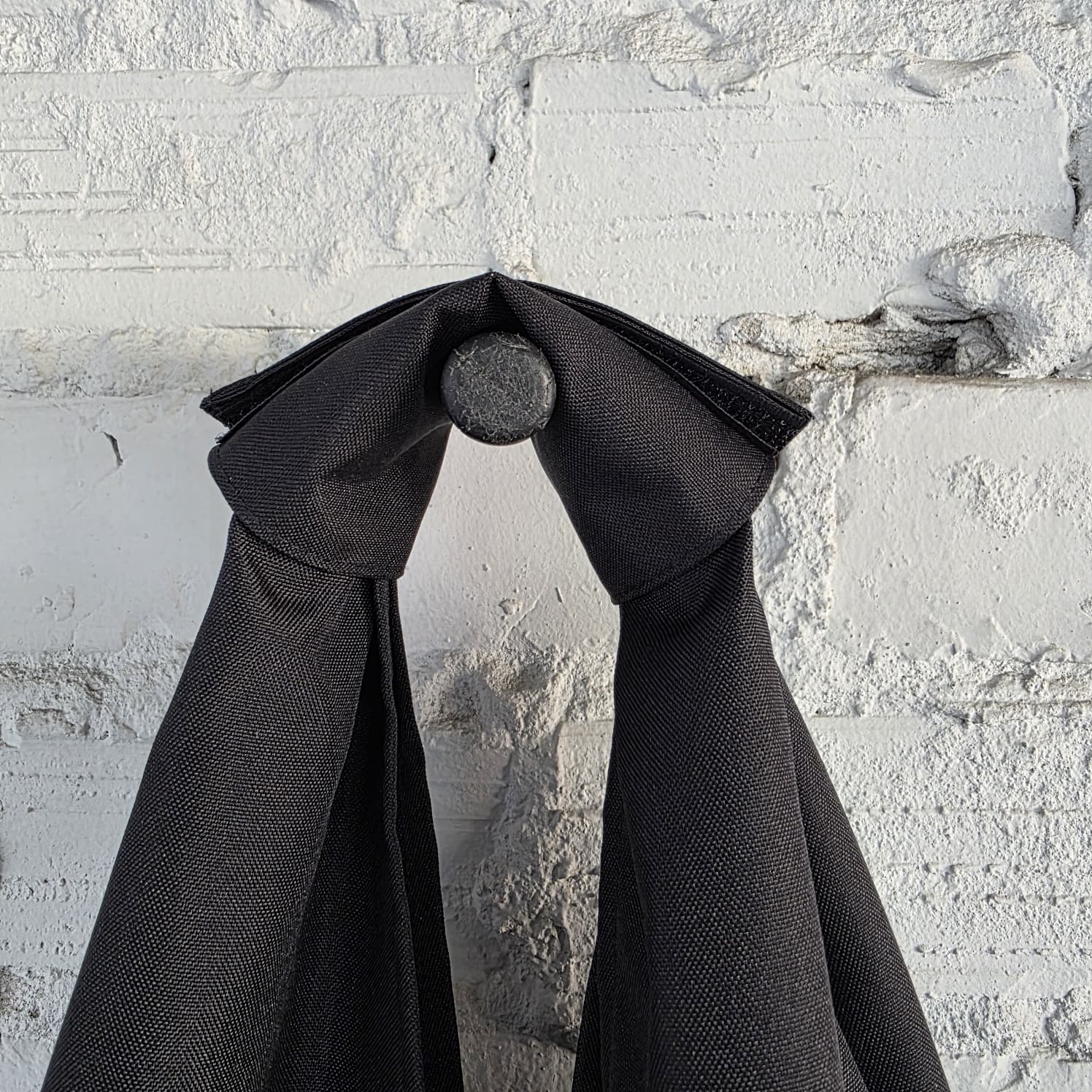 Folded handle detail of The Path Finder black HOBO bag — structured and sleek design