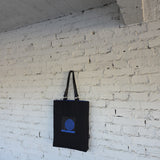 Side view of structured black embroidered tote bag with detachable leather handles, contemporary art-inspired handbag