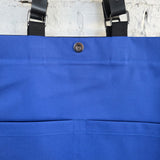 Interior of black canvas tote bag with bright blue lining and magnetic snap closure, spacious handmade laptop and work bag