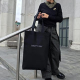 Close-up of “HAPPY DAY” embroidery on cotton fabric