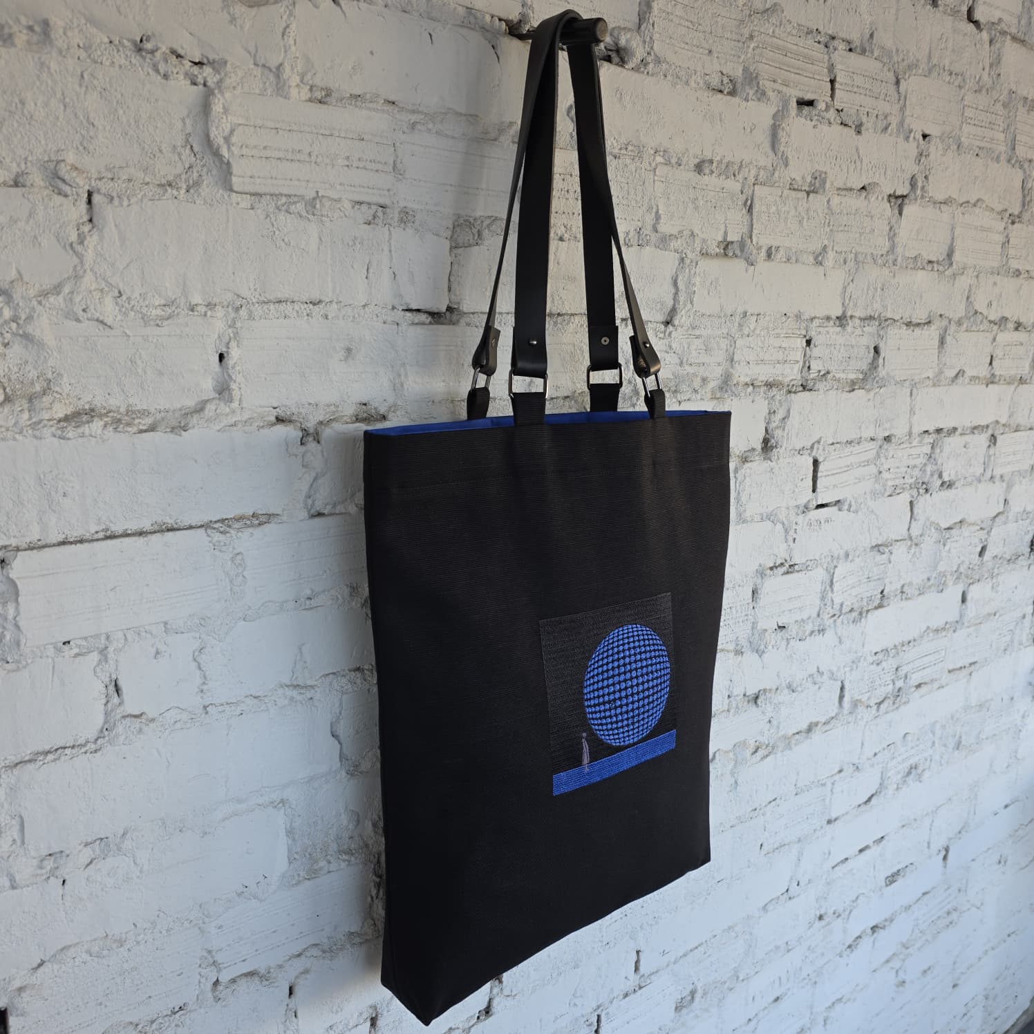 Black canvas tote bag with blue 3D geometric embroidery and detachable leather handles, modern minimalist handmade shoulder bag with artistic circular design