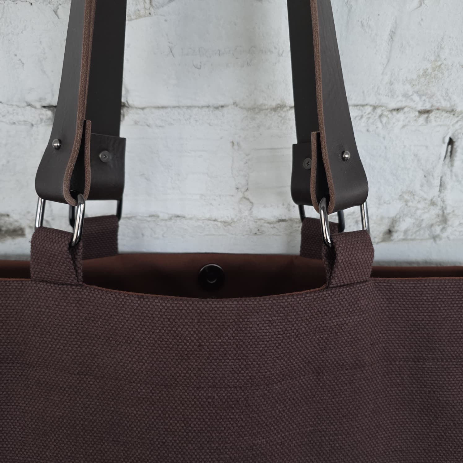 Interior view of brown canvas tote bag with snap closure and durable stitching
