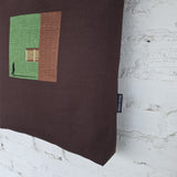 Side view of large brown canvas shoulder tote bag with structured shape and leather straps