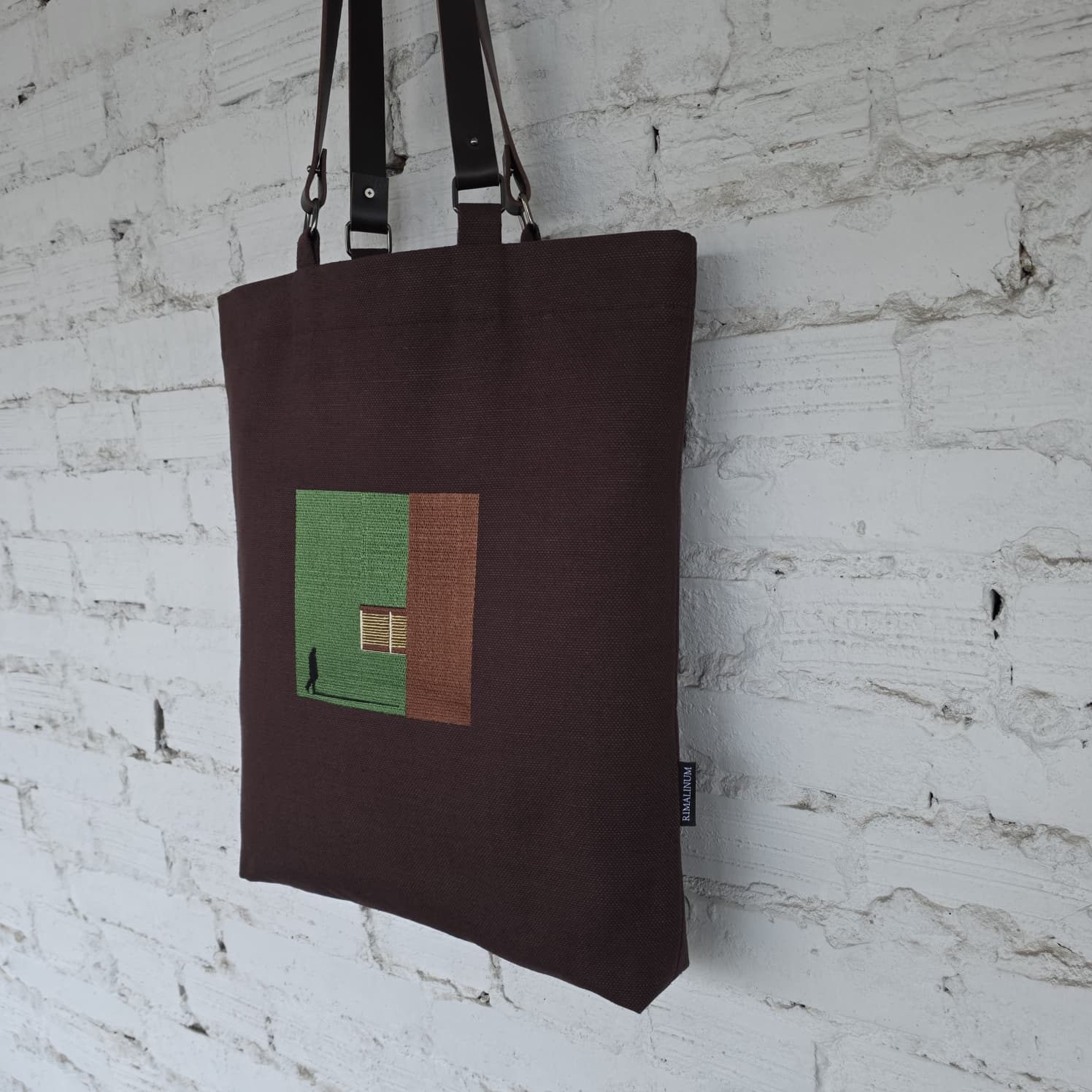 Close-up of brown handmade canvas tote bag showing texture and designer label detail