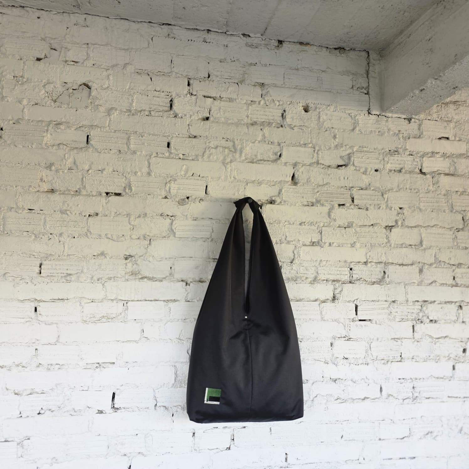 Black HOBO bag hanging display — slow fashion accessory handmade with precision.