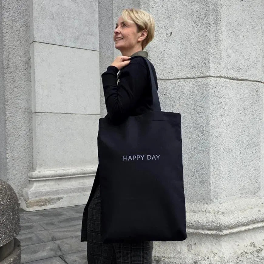 Smiling woman with large cotton tote bag “HAPPY DAY”