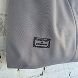 Embroidered label “Designed by RIMALINUM” on grey waterproof bag