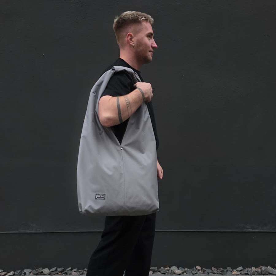 Man carrying large light grey unisex waterproof hobo bag – everyday minimalist tote