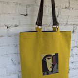 Detachable dark-brown leather handles on canvas tote