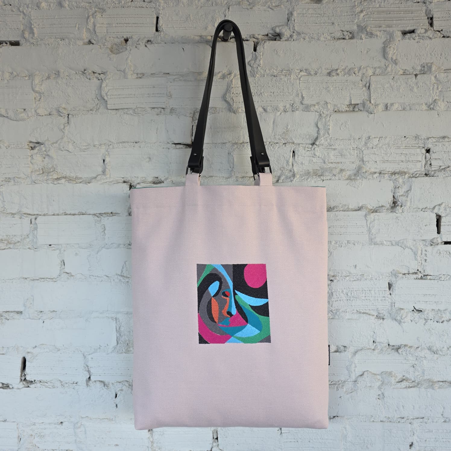 Pink embroidered tote bag with detachable leather handles, minimalist design