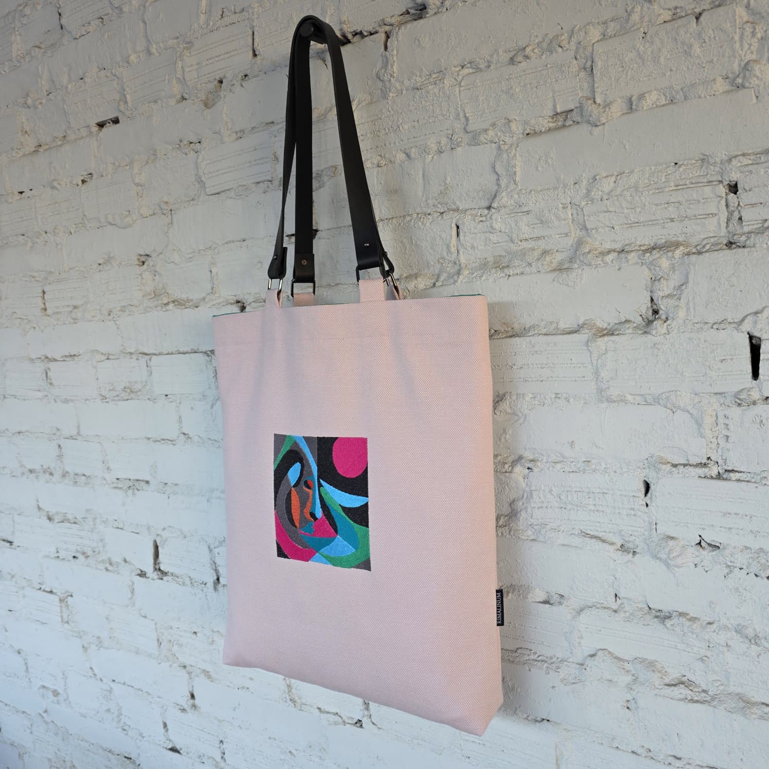 Pink handmade tote bag with embroidered abstract design and leather handles