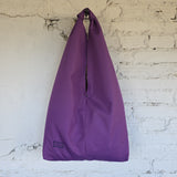 Front view of a large violet hobo bag with a wide shoulder handle, central opening and minimalist design.