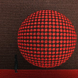 Detailed close-up of red 3D embroidered circle design on brown fabric tote bag